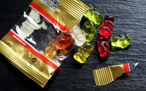 Osos de goma Haribo de colores esparcidos sobre una superficie oscura. ¡Cuidado, las chuches caducan!