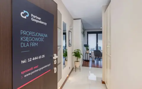 Tabliczka na drzwiach z logo "Partner Gospodarczy" i hasłem "Profesjonalna księgowość dla firm".