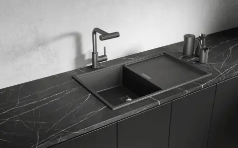 Nowoczesny, czarny zlew granitowy z baterią i ociekaczem na marmurowym blacie. Jakim środkiem czyścić czarny zlew, by lśnił?