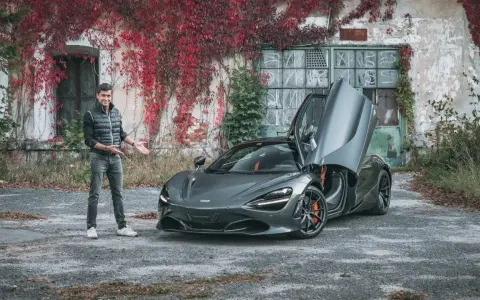 Mężczyzna prezentuje szarego McLarena 720S z otwartymi drzwiami. Zastanawiasz się nad mclaren 720s cena?