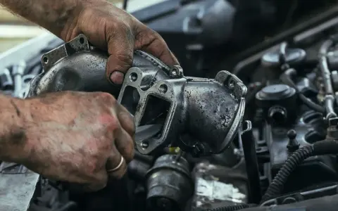 Mechanik czyści element układu recyrkulacji spalin, podejrzewając nadmierny przepływ.