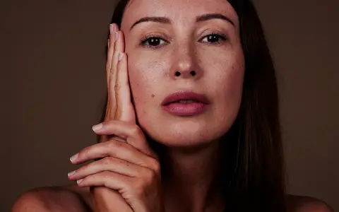 Nahaufnahme einer Frau mit Sommersprossen. Die sanfte glycolic acid wirkung lässt ihre Haut strahlen.