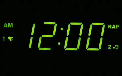 Budzik pokazuje 12:00 AM. To oznacza północ, początek dnia.