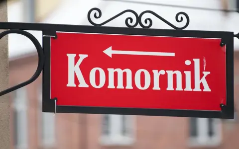 Tabliczka "Komornik" z białą strzałką w lewo. Zastanawiasz się, ile komornik może zabrać z emerytury?