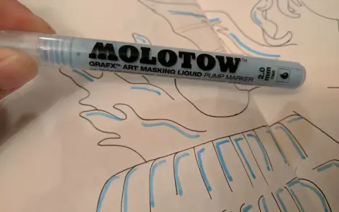 A hand holds a light blue Molotow Grafx Art Masking Liquid Pump Marker over a drawing.