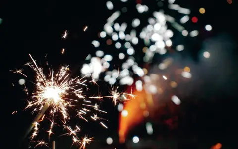 Funkelnde Wunderkerzen und verschwommene Lichter am Silvesterhimmel in Minden.