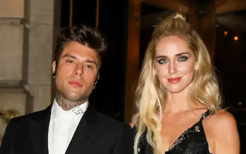 Chiara Ferragni i Fedez pozują do zdjęcia. Ona ma blond włosy upięte w kok, a on tatuaże na szyi.
