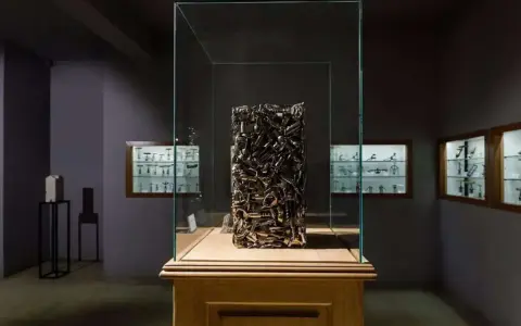 Sculpture en tire-bouchons dans une vitrine au musée du tire bouchon. Des vitrines murales exposent d'autres tire-bouchons anciens.