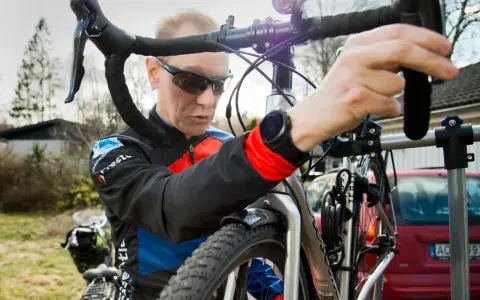 Man i cykelkläder fokuserar på att laga punktering på sin cykel.