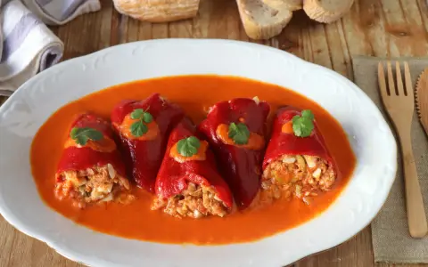 Pimientos del piquillo rellenos de atún y huevo, servidos en una salsa roja cremosa.