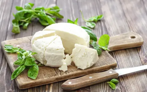 Chudy twaróg na desce z bazylią. Zastanawiasz się, ile białka ma twaróg chudy? To świetne źródło protein!