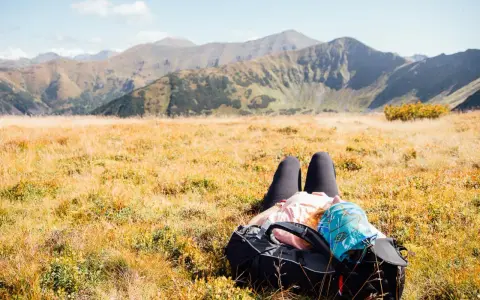 Odpoczynek w jesiennych Tatrach. Po wędrówce, gdzie w Tatry, można się zrelaksować na trawie, podziwiając góry.