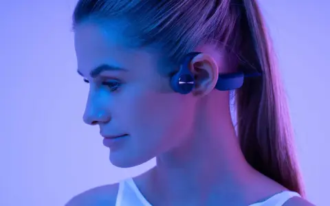 Une femme porte un casque à conduction osseuse. Ce type de casque peut présenter un danger si l'on n'est pas attentif à son environnement.