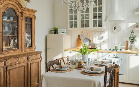 Table dressée pour un repas, avec un buffet ancien et une cuisine lumineuse, évoquant une ambiance de spécialité provençale.
