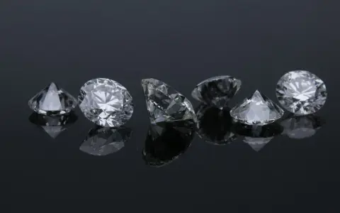 Siedem błyszczących diamentów na czarnym tle. Co oznacza diament na sympatii? Symbol trwałości i piękna, jak te kamienie.