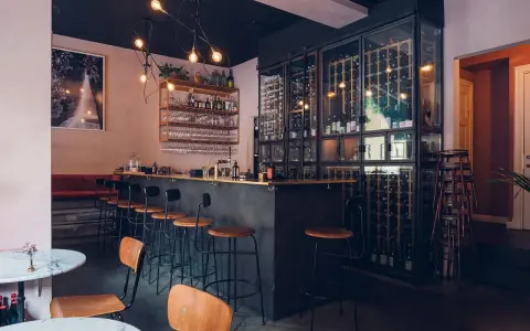 Mysig vinbar i Stockholm med en stor vinkyl, bardisk och sittplatser.