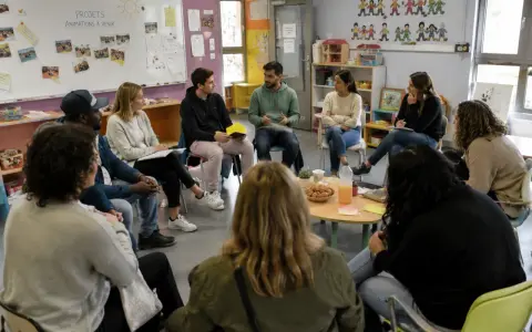 Des participants échangent lors d'une formation, peut-être des stages BAFA, dans une salle colorée.