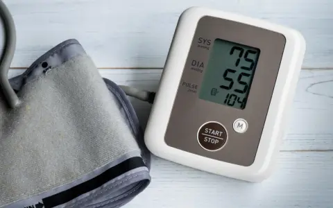 Misuratore di pressione con bracciale e display che mostra 75/55, valori che potrebbero indicare pressione bassa anziani 90 anni.