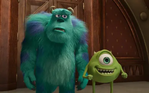 Sully i Mike, bohaterowie bajek z 4 postaciami, stoją obok siebie. Sully wygląda na zmartwionego, a Mike uśmiecha się szeroko.