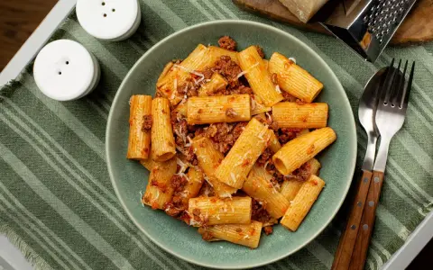 Pyszne rigatoni z sosem bolońskim, posypane parmezanem. Idealne danie, czy to rigatoni czy ziti, zawsze smakuje wybornie!