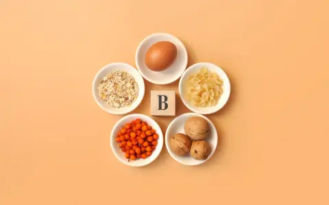 En ägg, havregryn, pasta, havtorn och valnötter arrangerade runt en träkub med bokstaven B, som symboliserar alla b-vitaminer.