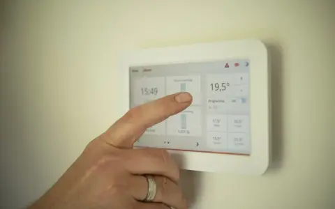 Dedo interactúa con un termostato modulante, ajustando la temperatura a 19,5°C.