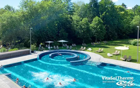 Erfrischendes Schwimmbad mit Liegen und Sonnenschirmen im Außenbereich der VitaSol Therme Bad Salzuflen.