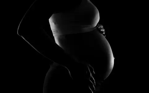 Silhuett av en gravid kvinna som håller sin mage. Bilden kan associeras med vena cava syndrom gravid.