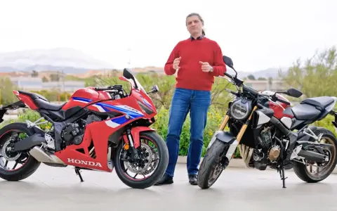 Mężczyzna w czerwonym swetrze prezentuje dwa motocykle Honda: sportowy CBR i naked bike CB650R.