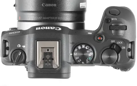Górna część aparatu Canon R8 z widocznym pokrętłem trybów, przyciskiem M-Fn i włącznikiem. Sprawdź atrakcyjną canon r8 cena!