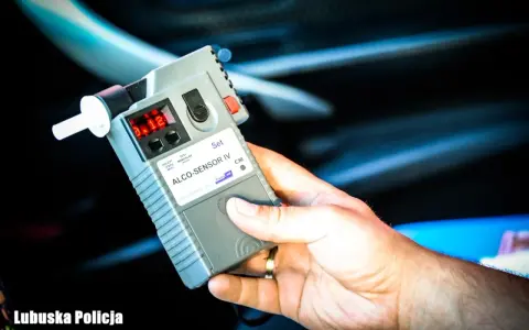 Dłoń trzyma alkomat ALCO-SENSOR IV, wskazujący wynik 0.12. To dowód na podważenie badania alkomatem, gdy wynik jest niejednoznaczny.