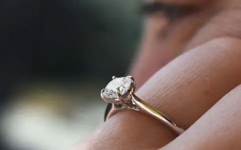 Un anello di fidanzamento con diamante solitario, un classico tra i tipi di anelli di fidanzamento, brilla su un dito.