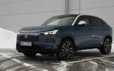 Ciemnoniebieski Honda HR-V na tle śniegu i szarej ściany.