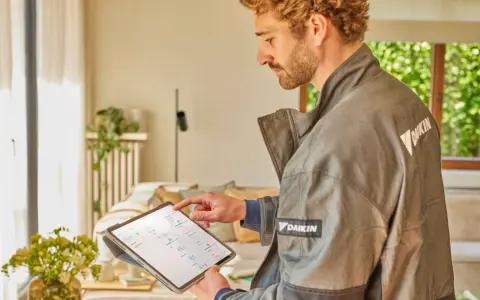 Técnico revisa datos en tablet para el mantenimiento de bomba de calor.