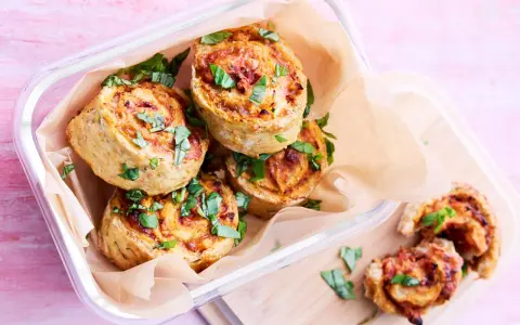 Läckra pizza bullar i en glasburk, toppade med färsk basilika. Perfekta för en picknick eller som mellanmål.