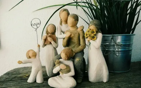 Eine griechische Familie aus Figuren: Vater, Mutter, zwei Mädchen, ein Junge und ein Baby. Ein Mädchen hält ein Buch, ein anderes Sonnenblumen.