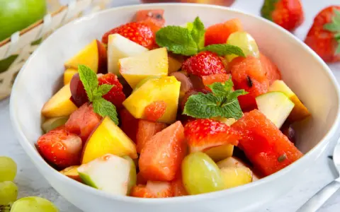 Ein bunter Obstsalat mit Erdbeeren, Melone, Pfirsich und Trauben – ein einfaches obstsalat rezept für heiße Tage.