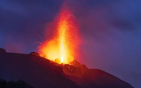 Spektakuläre Eruption eines Vulkans in Europa. Glühende Lava schießt in den Nachthimmel, ein beeindruckendes Naturschauspiel.