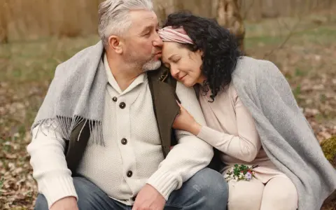 Para spędza czas na łonie natury, czule przytulanie się i dzielenie ciepłem pod kocem.