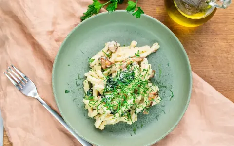 Krämig svamp pasta med färska örter på en grön tallrik, redo att avnjutas.