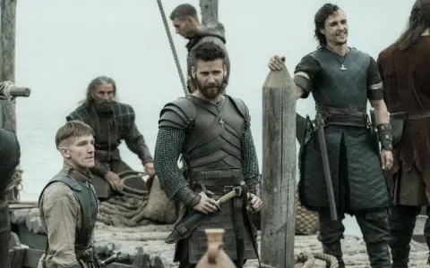 Bohaterowie The Last Kingdom w zbrojach i z bronią, gotowi do walki na statku.