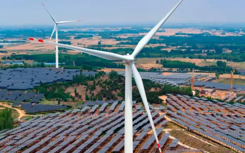 Große Windturbinen und weite Felder von Solarmodulen zeigen Chinas Engagement für erneuerbare Energien.