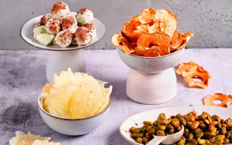 Leckere filmabend snacks: weiße Schoko-Bällchen, Apfelchips, knusprige Cracker und gewürzte Edamame.