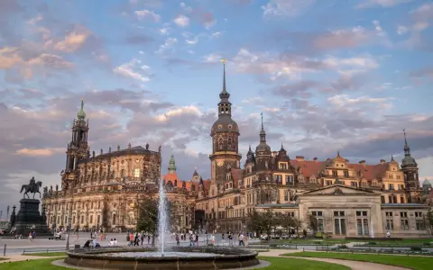 Zamek w Dreźnie z fontanną i pomnikiem konnym na placu. Architektura zachwyca o zachodzie słońca.