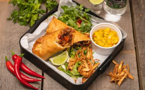 Chrupiące rolki z nadzieniem mięsnym i warzywnym, podane z salsą mango, sałatką i limonką. Prawdziwy smak tex mex!