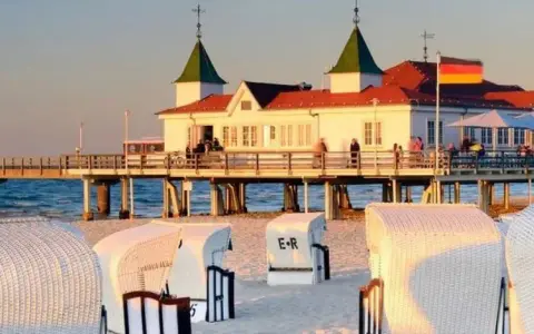 Plaża w Ahlbecku z molo i charakterystycznymi koszami plażowymi. Idealne miejsce na relaks i podziwianie zachodu słońca.