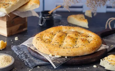 Frisch gebackenes Fladenbrot mit Sesam und Schwarzkümmel, bereit zum Genießen. Selbst Fladenbrot backen ist eine Freude!