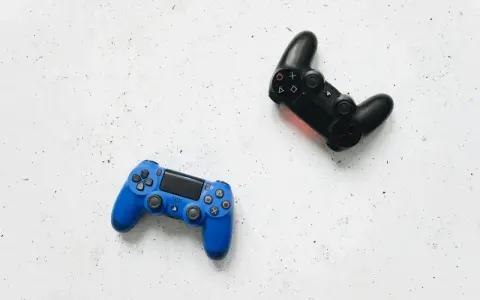Dos mandos de videojuego, uno azul y otro negro, listos para una intensa sesión de videojuego de acción y aventura.