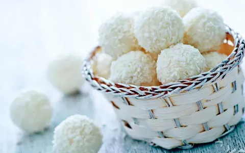 Délicieuses boules coco, parfaites pour une recette facile et rapide. Un panier rempli de ces douceurs vous attend.