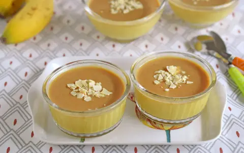Postres de plátano en copas de cristal, decorados con láminas de almendra.